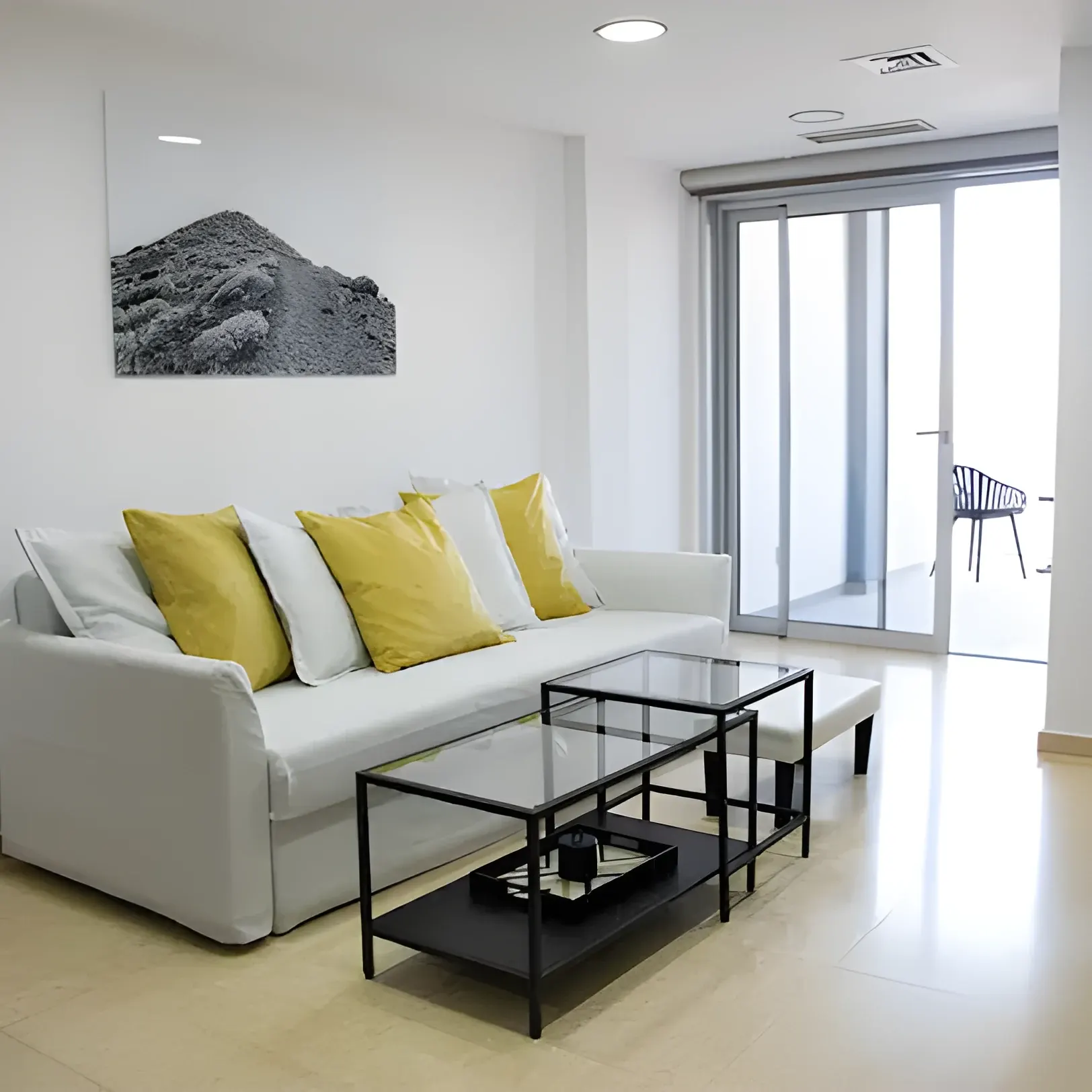 Salón luminoso con sofá y acceso a la terraza