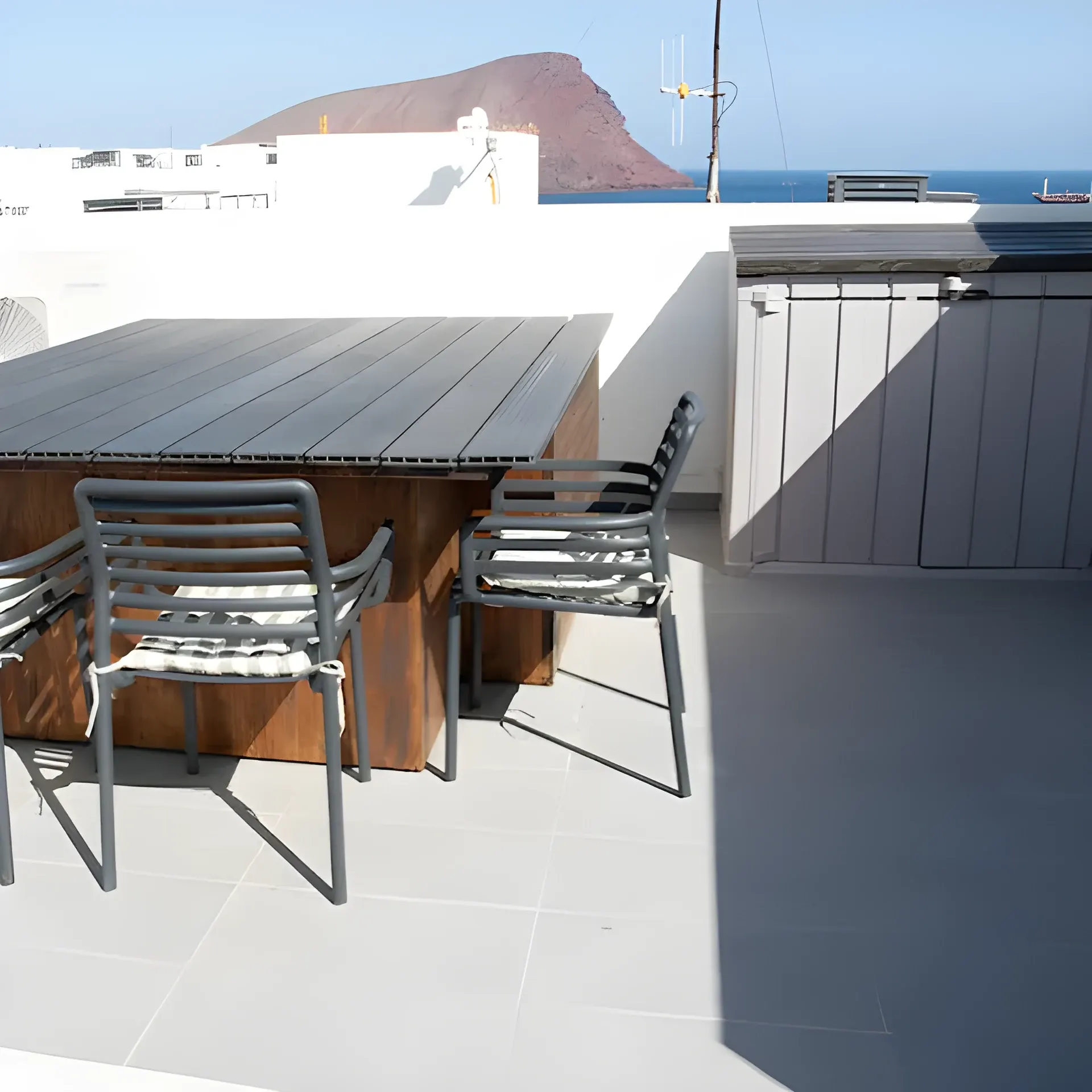 Comedor exterior de la azotea con Montaña Roja y el mar al fondo
